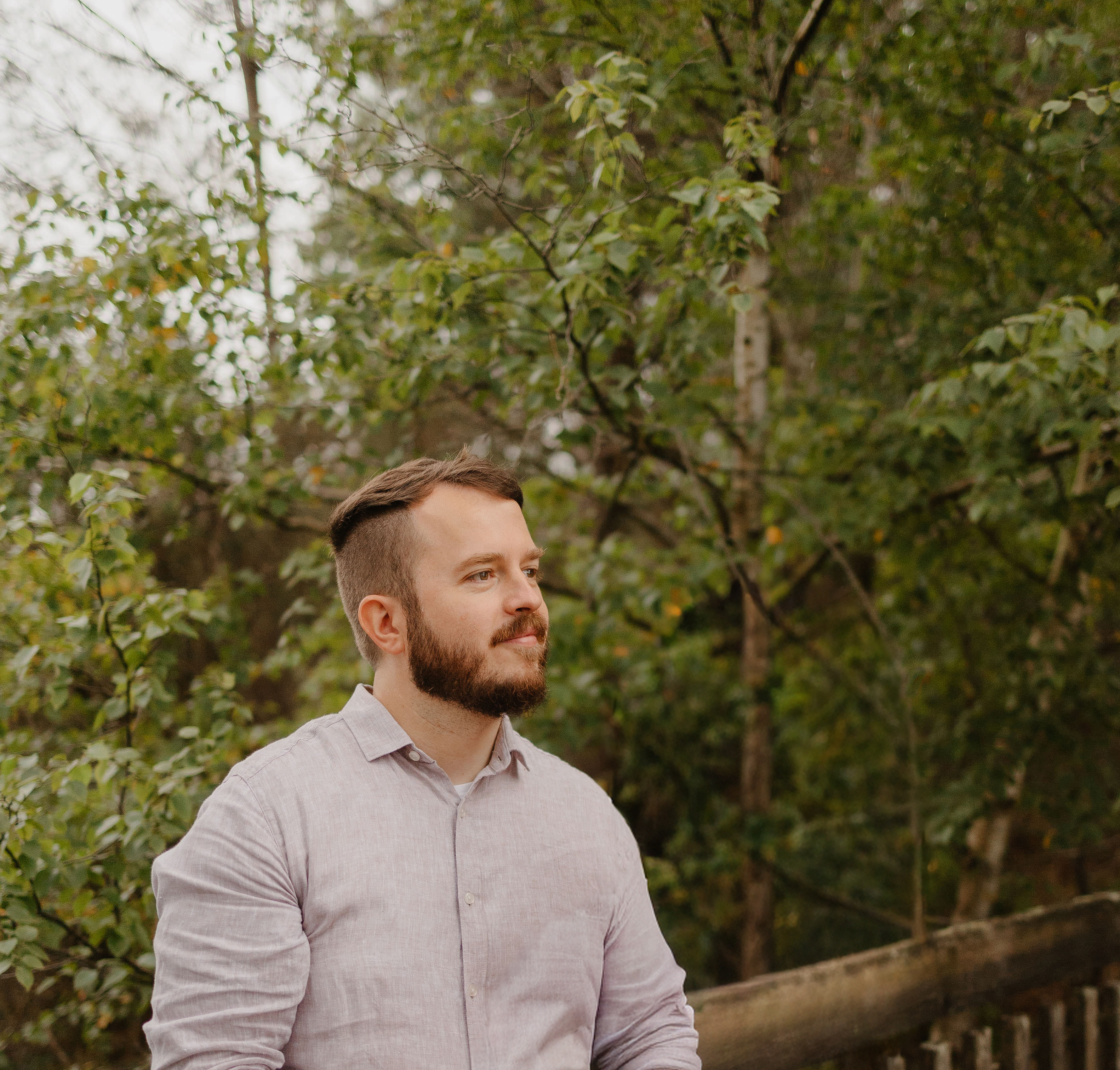 Fabien regardant au loin dans une forêt.